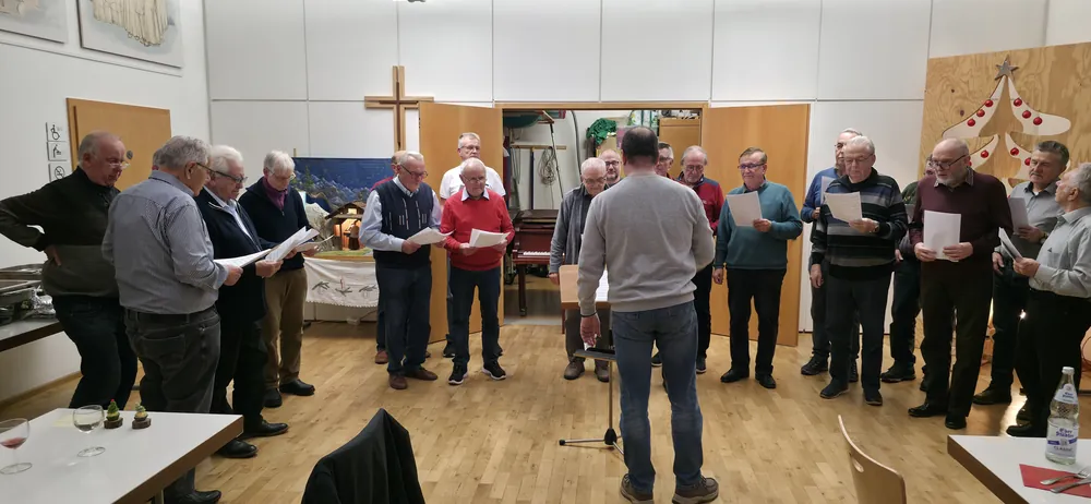 Der Männerchor der Concordia singt im Kreis, der Dirigent steht mit dem Rücken zur Kamera